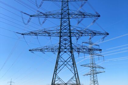 Lignes électriques à haute tension sous un ciel bleu clair, illustrant la puissance et la distribution d'énergie. Lignes électriques à haute tension sous un ciel bleu clair, illustrant la puissance et la distribution d'énergie.