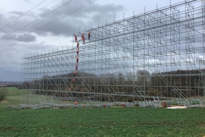 Construção de palco com Cteam, trabalhadores em andaimes altos e estrutura metálica complexa. Construção de palco com Cteam, trabalhadores em andaimes altos e estrutura metálica complexa.