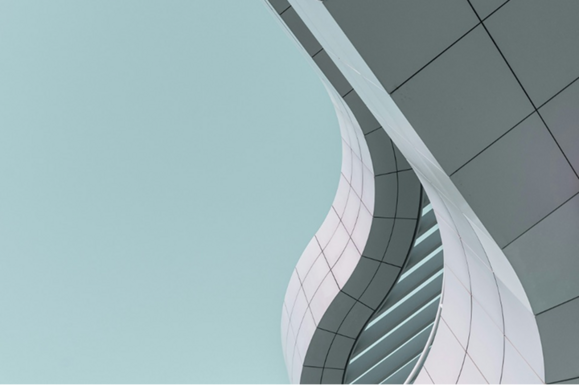 Modernas arhitektūras ēkas fasāde ar cieto metāla konstrukciju, kas atgādina viļņu formu, ideāli piemērota biznesa centriem vai jaunām būvēm.