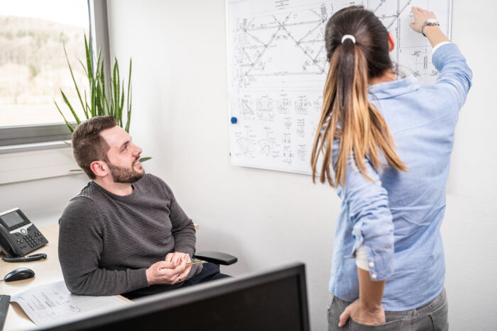 Mitarbeiter von Cteam besprechen technische Zeichnungen f&uuml;r Anlagenbau-Projekte.